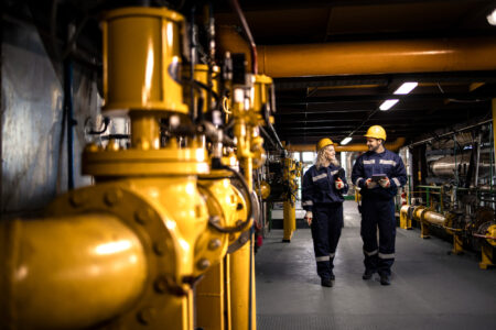 A man and a woman walking through a hallway at an oil processing facility