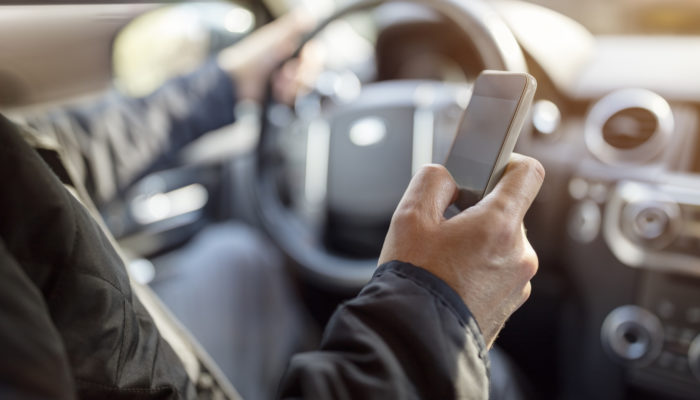 Using a phone in a car texting while driving concept for danger of text message and being distracted